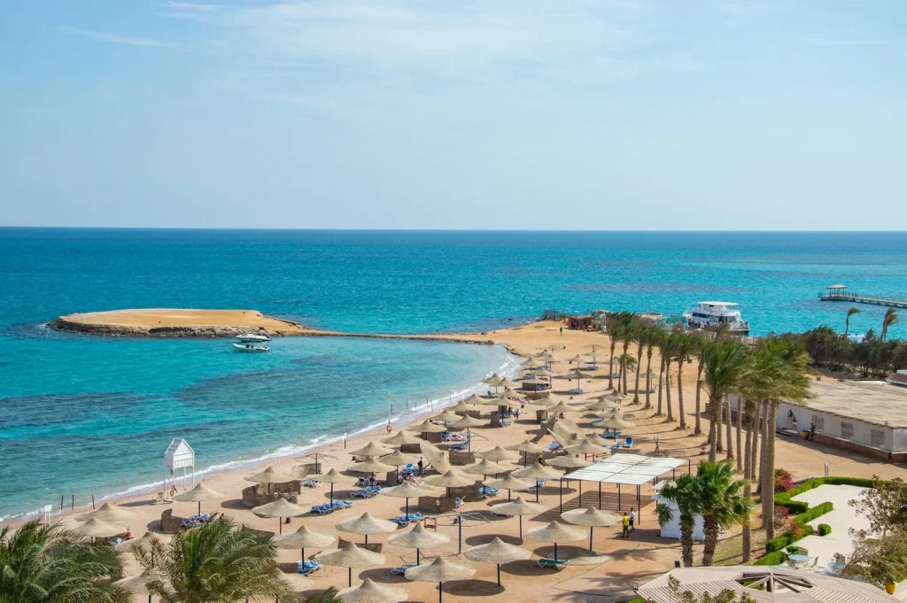 Idyllic beach scene with rows of umbrellas and azure ocean, perfect for travel and relaxation themes.