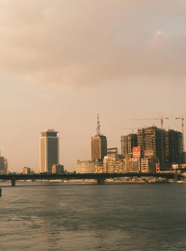 A scenic view of Cairo's skyline along the Nile River at sunset, capturing the city's modern architecture.