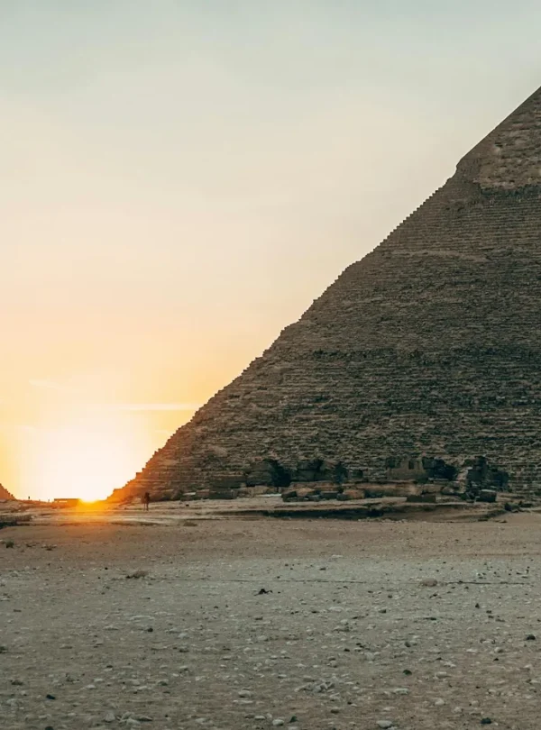 Dramatic sunset view of the iconic Giza Pyramids in Egypt, highlighting their ancient architecture.