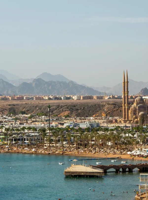 A stunning aerial view of Sharm El Sheikh featuring the coastline and city landmarks against a mountainous backdrop.