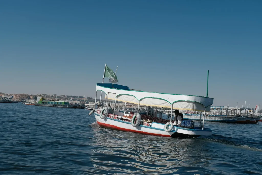 Scenic view of a traditional boat sailing on the Nile River under a clear blue sky.