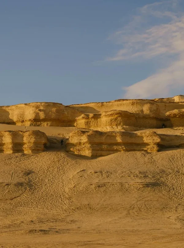 Scenic view of sunlit sandstone cliffs in Faiyum, Egypt during sunset.