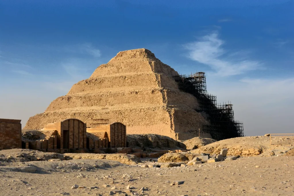 Step Pyramid of Djoser in Saqqara under restoration with clear blue sky.