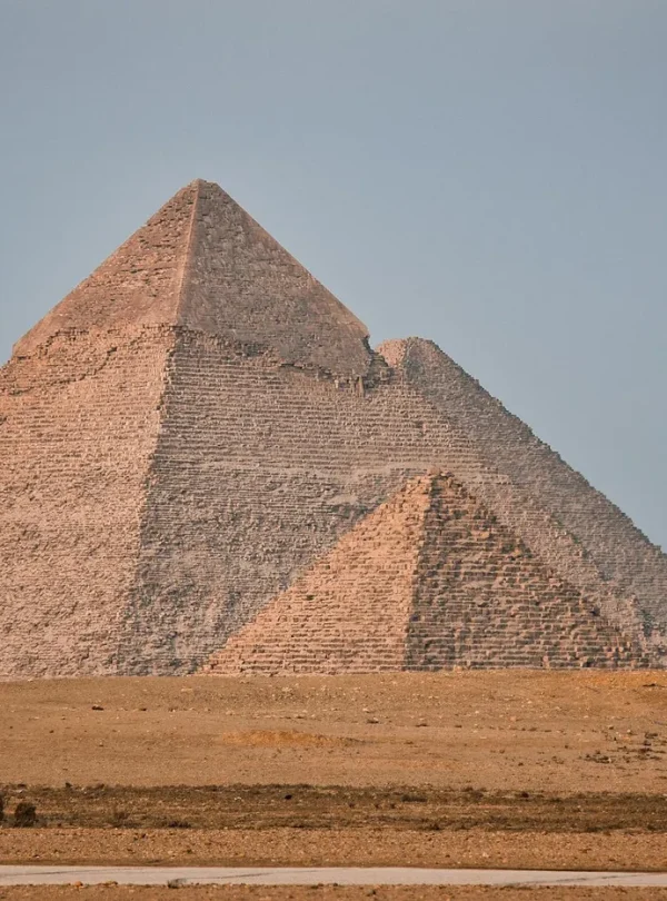 The iconic Great Pyramid of Giza standing tall in the Egyptian desert under a clear blue sky.
