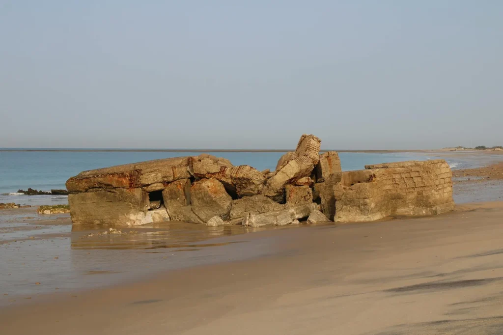 Old bunker ruins on a serene beach in San Fernando, Spain.