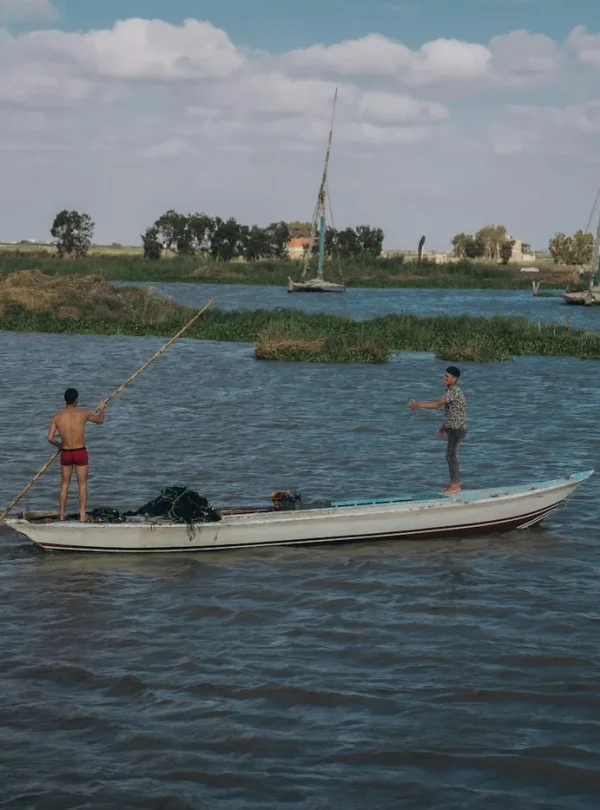 Two fishermen engage in traditional fishing on the Nile River, capturing authentic Egyptian culture.