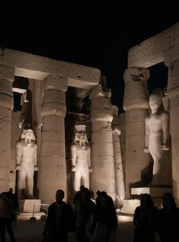 Illuminated statues at Luxor Temple under the night sky, showcasing Egyptian history.