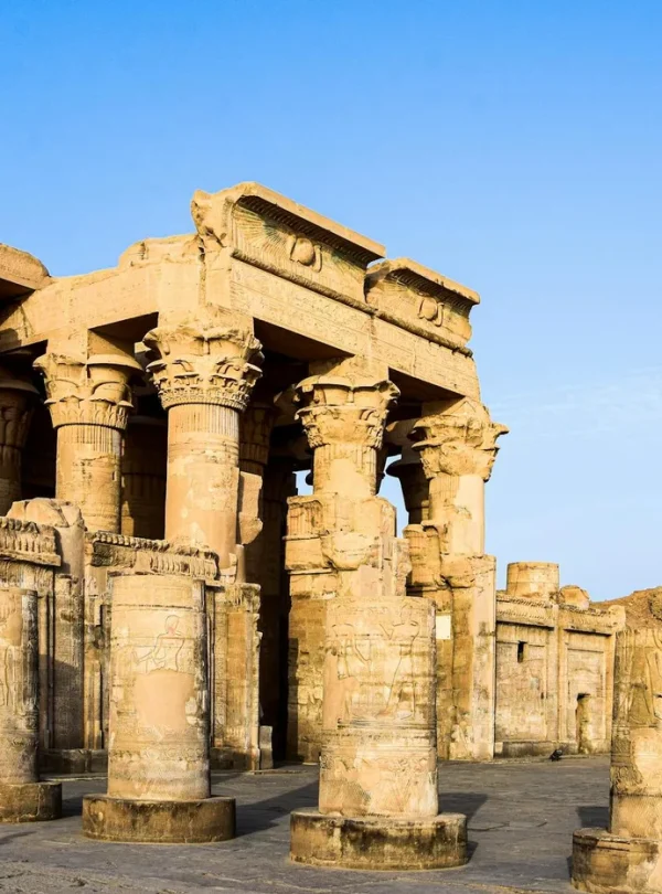 Explore the stunning ancient Egyptian temple ruins featuring iconic columns under a clear blue sky.